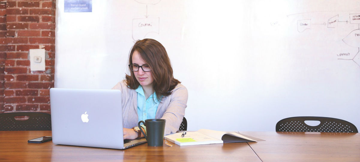 Female employee at desk using mac laptop